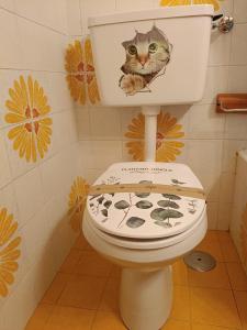 a cat sitting on top of a toilet in a bathroom at Lo Gnomo Apartment in Marilleva +44 photos