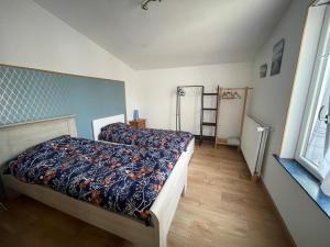 a bedroom with a bed with a comforter on it at Au gîte des Frangines in Grand-Fort-Philippe