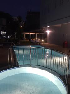 a swimming pool at night with a railing at Karon Place in Karon Beach