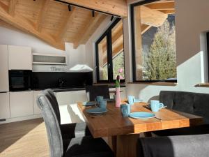 a kitchen and dining room with a wooden table and chairs at NEUBAU Alpinstar Chalet - Luxus, Bergblick, Loipe, Sauna in Leutasch