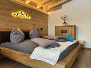 two beds in a room with wooden walls at NEUBAU Alpinstar Chalet - Luxus, Bergblick, Loipe, Sauna in Leutasch