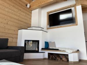 a living room with a fireplace and a flat screen tv at NEUBAU Alpinstar Chalet - Luxus, Bergblick, Loipe, Sauna in Leutasch