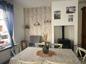 a dining room with a table and a fireplace at Au gîte des Frangines in Grand-Fort-Philippe