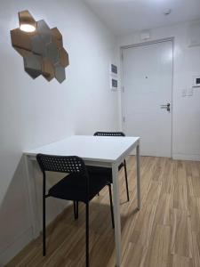 a white table and chairs in a room with a door at Cozy Studio Long Stays Welcome in Biñan +9 photos