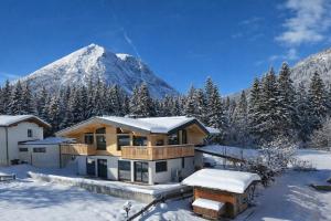 a house in the snow with a mountain in the background at NEUBAU Alpinstar Chalet - Luxus, Bergblick, Loipe, Sauna in Leutasch