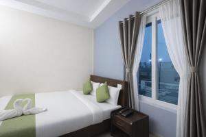 a bedroom with a bed and a large window at Orchid Palace in Gauhāti