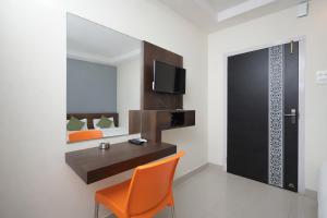 a room with a desk and a chair and a tv at Orchid Palace in Gauhāti