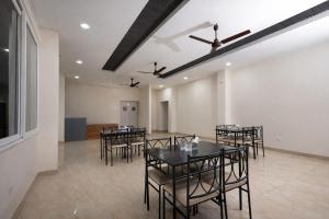 a dining room with black tables and chairs at Orchid Palace in Gauhāti