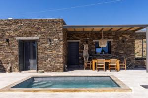 a patio with a swimming pool in front of a house at Marilias cycladic home in Agios Fokas +23 photos