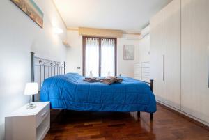 a bedroom with a blue bed and a window at Dreamescape House in Alzano Lombardo