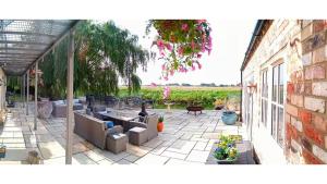 a patio with couches and a table at Riverside Lodge Self-Catering Apartment in Peterborough