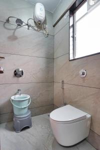 a bathroom with a toilet and a sink and a window at Hotel Palmera Inn in Pune +16 photos