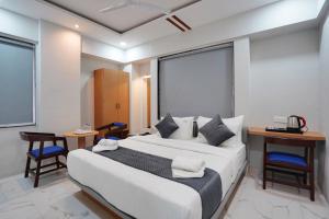 a bedroom with a large bed and a table and chairs at Hotel Palmera Inn in Pune