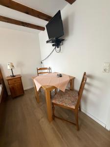 a dining room with a table and a tv on the wall at Pension Silberdistel in Ühlingen-Birkendorf