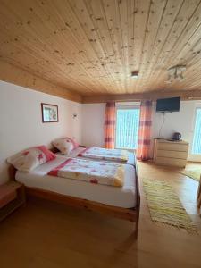 a bedroom with a large bed with a wooden ceiling at Pension Silberdistel in Ühlingen-Birkendorf