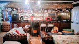 a living room with leather couches and a bar at Riverside Lodge Self-Catering Apartment in Peterborough
