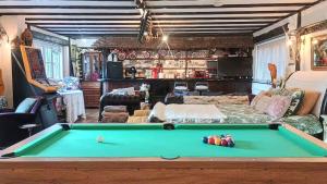 a living room with a pool table in the middle at Riverside Lodge Self-Catering Apartment in Peterborough +13 photos