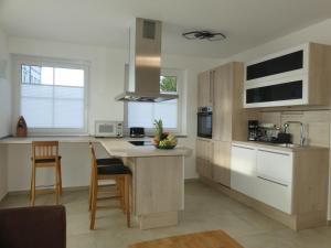 a kitchen with wooden cabinets and a island with chairs at Marktperle in Sagard
