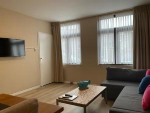 a living room with a couch and a table at Fisherman's House by Hofstad Hotels in Scheveningen