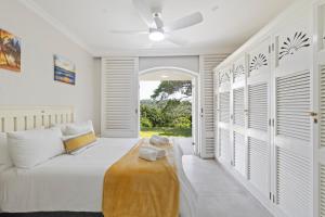 a bedroom with a bed and a ceiling fan at 9 Montego Bay Caribbean Estates in Port Edward +33 photos