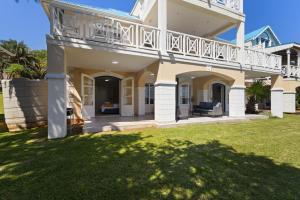 a large house with a balcony and a yard at 9 Montego Bay Caribbean Estates in Port Edward