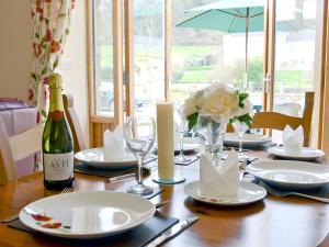 a dining room table with a bottle of wine and glasses at The Dairy - Op3 in Carmarthen