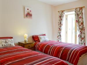two beds sitting next to each other in a bedroom at The Dairy - Op3 in Carmarthen +5 photos