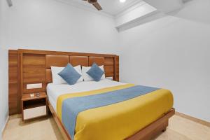 a bedroom with a bed with yellow and blue pillows at Hotel Dream Inn Thane in Thane +46 photos