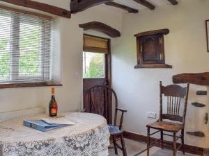 a room with a table and chairs and a bottle of wine at Stable Cottage in Windermere