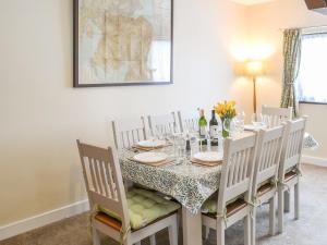 ein Esszimmer mit einem Tisch, Stühlen und Weingläsern in der Unterkunft Thistle Dee in Wooler
