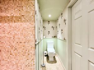 a bathroom with a toilet next to a brick wall at Cottage 3 - Uk46609 in Broughton