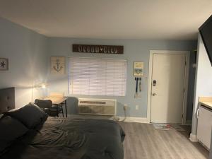 a bedroom with a bed and a desk and a window at Sunbeach Condo 900 Wesley Avenue Unit 109 in Ocean City