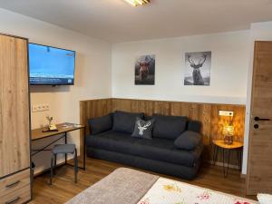 a living room with a couch and a flat screen tv at Appartement Steinbergrose in Leogang