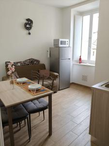 a kitchen and living room with a table and a refrigerator at JeD SWEET DREAMS in LʼAquila