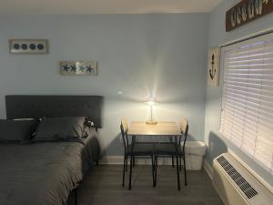 a bedroom with a bed and a table with a lamp at Sunbeach Condo 900 Wesley Avenue Unit 109 in Ocean City