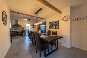 a dining room and kitchen with a table and chairs at The Eau Rouge 600m from the entrance of the circuit in Stavelot