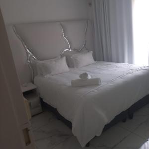 a white bed with a white tray on top of it at Comfort Retreat in Roodepoort +5 photos