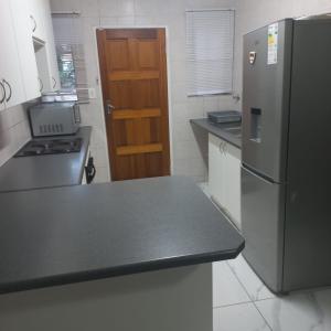a kitchen with a black counter top and a refrigerator at Comfort Retreat in Roodepoort