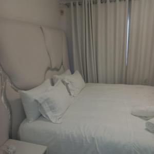 a white bed with white pillows in a bedroom at Comfort Retreat in Roodepoort