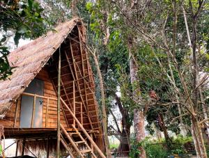 a tree house with a thatched roof at Pemsee's Tree Town - Eco Treehouse Hostel in Sauraha +152 photos