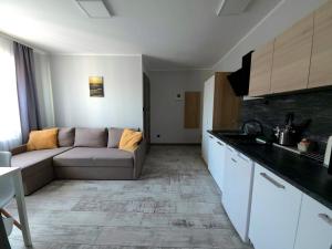 a living room with a couch and a kitchen at Pokoje Sandra I in Łeba +99 photos