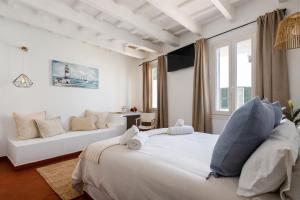 a white bedroom with a large bed and a couch at Hotel Boutique Ses Penyes in Alaior
