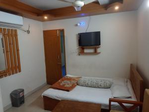 a small room with a bed and a flat screen tv at Hotel Sikder-02 Residential in Dhaka
