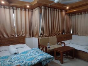 a bedroom with a bed and a desk and a table at Hotel Sikder-02 Residential in Dhaka