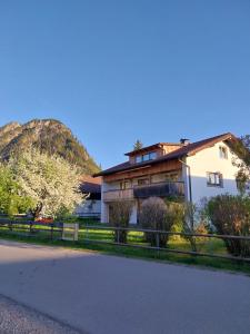 a house with a fence in front of a mountain at Alpinchalet in Pfronten