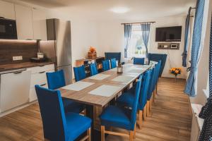 a dining room with a long table and blue chairs at Ubytování Třemešek in Šumperk +7 photos