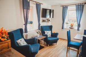 a living room with blue chairs and a table at Ubytování Třemešek in Šumperk