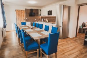 a dining room with a long table and blue chairs at Ubytování Třemešek in Šumperk
