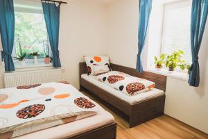 a bedroom with two beds and a window with blue curtains at Ubytování Třemešek in Šumperk
