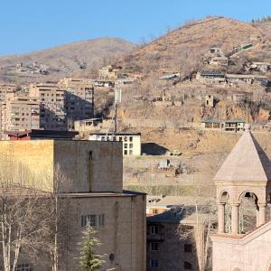 a city with buildings and a mountain in the background at AMare guesthouse in Kapan